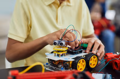 Student wiring ultrasonic sensor module to microcontroller breadboard shield